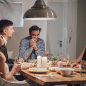 Freunde beim gemeinsamen Abendessen lachen miteinander Freunde beim gemeinsamen Abendessen lachen miteinander